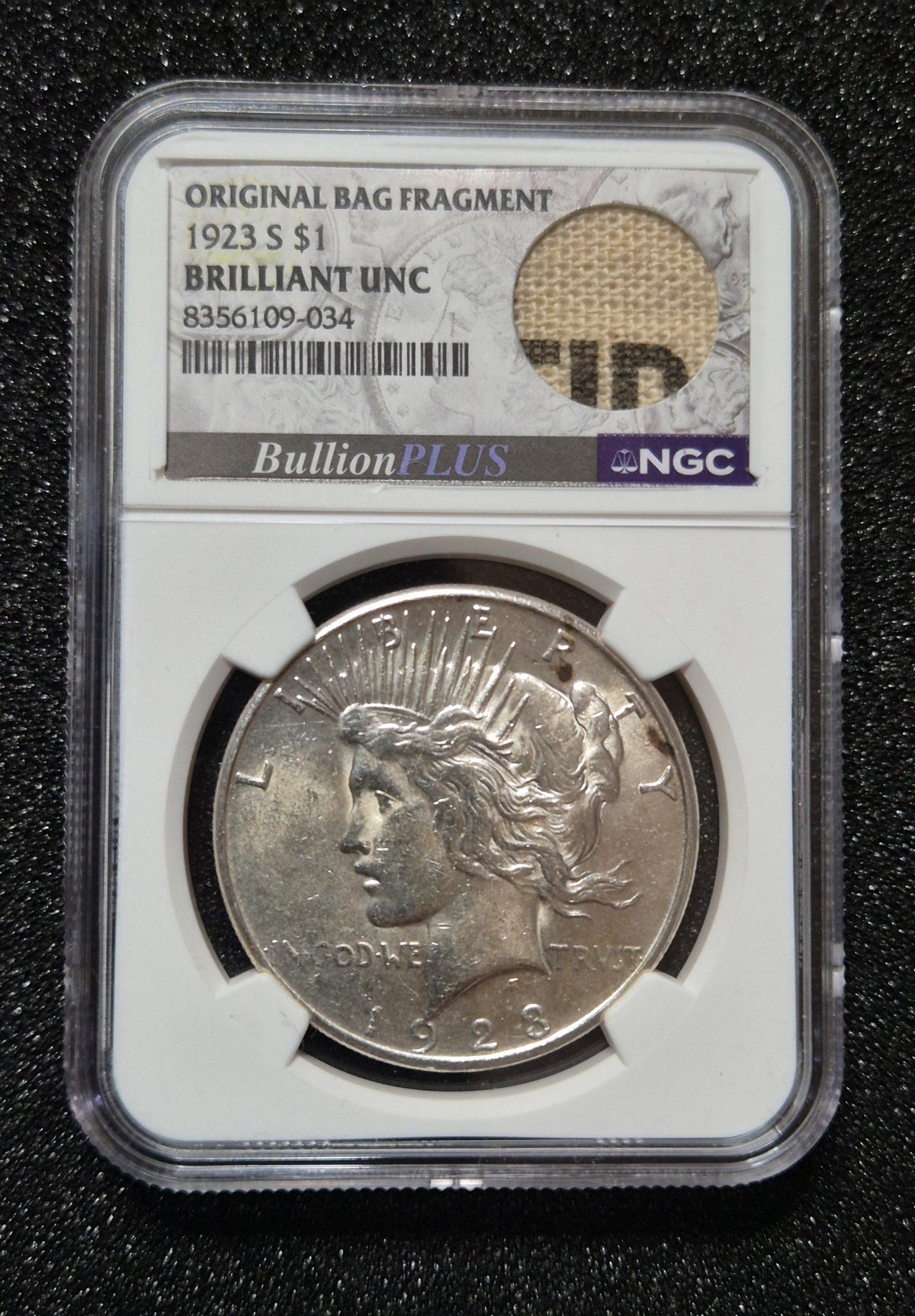 1923 Peace Dollar - Brilliant Uncirculated, with Rare Inked Bag Fragment. Certified by NGC.